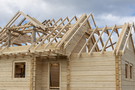 正在建造的木制房屋的结构结构小屋工地房子蓝色横梁屋顶建设材料窗户木工图片