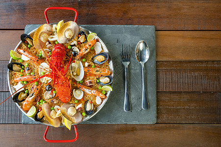 配有新鲜龙虾 蛤 贝类和石灰甲壳鱿鱼藏红花食谱传统平底锅食物海鲜饭美味服务图片