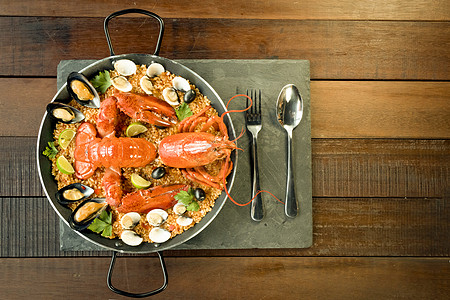 龙虾大哥配有新鲜龙虾 蛤 贝类和石灰海鲜藏红花海鲜饭美味动物传统石板甲壳食物美食背景