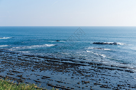 日本宫崎市的恶魔洗脸板海滩晴天旅行石头海岸蓝色海岸线巨浪岩石神社图片