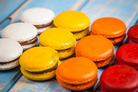 富彩多彩的法国马卡龙白色蛋糕食物糖果橙子巧克力小吃奶油糕点红色背景图片