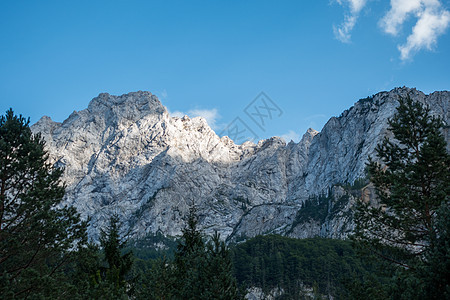 蓝天空高山峰和前方森林高山峰图片