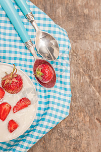 在一杯酸奶和新鲜草莓 蓝汤匙毛巾上杯子早餐饮食小吃食物厨房桌子营养奶油勺子图片