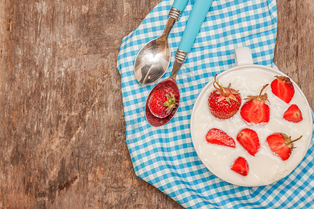 在一杯酸奶和新鲜草莓 蓝汤匙毛巾上小吃健康桌子奶油水果盘子覆盆子奶制品厨房美食图片