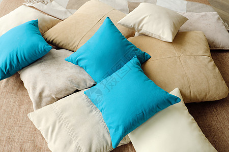 蓝色床床铺上丰富多彩的枕头温暖和舒适褐色蓝色白色棉布背景