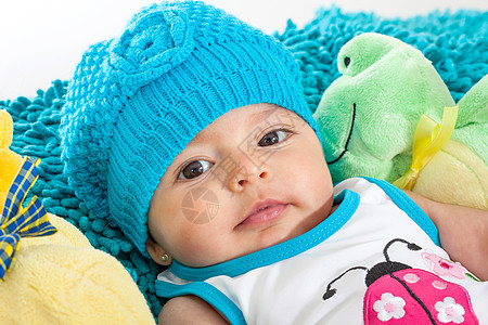 4个月大 身着蓝帽子的女婴女性童年压痛蓝色女孩快乐帽子说谎几个月微笑图片