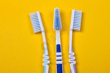 三个黄色背景的牙刷 W牙医卫生家庭舌头浴室保健呼吸蓝色药品牙膏图片