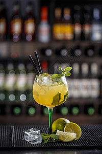 鸡尾酒加石灰片和薄荷叶饮料玻璃酒吧果汁酒精柠檬水果叶子黄色餐厅图片
