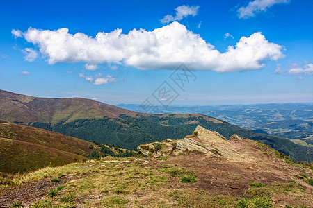 夏季山边草地荒野石头山坡旅行巨石天空森林木头场地场景图片