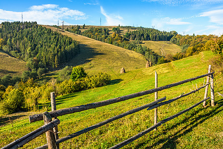 山坡上草地上的木栅栏蓝色农村森林草垛环境天空天气木头边界爬坡图片