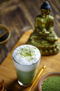 Matcha 绿色茶饮料泡沫拿铁粉末液体奶油状玻璃木头冰沙酒吧图片