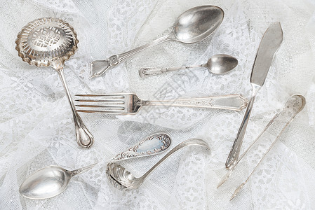 白色带子上的银器餐具桌子蕾丝风格刀具复古烹饪勺子纺织品宏观图片