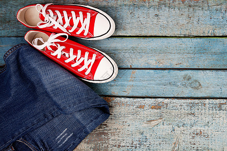 蓝木木背景的红色复古运动鞋和牛仔裤木头青少年男人时尚生活配饰白色旅行牛仔布衣服图片