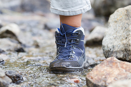妇女穿越瀑瀑     有选择的焦点旅行女性蓝色靴子鞋带女孩探索女士石头蕾丝图片
