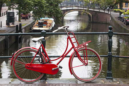 在阿姆斯特丹的一座桥上骑着红色自行车图片