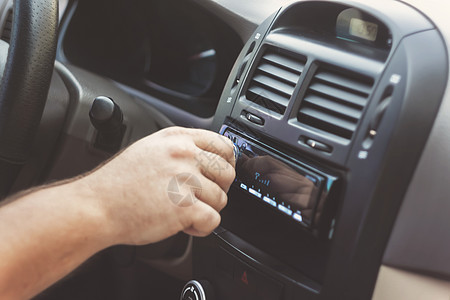 男人的手扭动音量 在回溯汽车音乐力量空气光盘运输玩家护发素控制司机音乐播放器图片