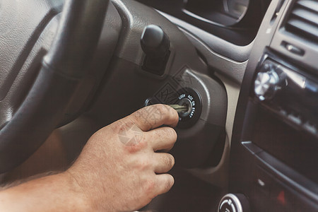 男人的手用钥匙开着车 在回过往的时候点燃驾驶引擎电气发动机成人速度运输男性按钮图片