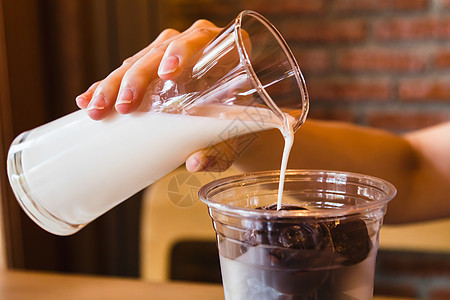 用冷冻巧克力将新鲜牛奶倒入玻璃杯图片