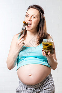 肚子饿的孕妇和一罐咸黄瓜对着一个图片