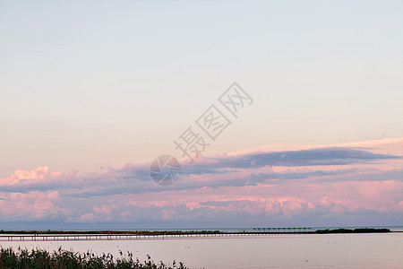 横跨大桥的风景长桥 海面上盖着美丽的粉色阳光紫红色场景蓝色地平线码头植物太阳天空旅行农村图片