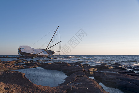 帆船困在岩石上日出风暴情况海岸线游艇保险海岸蓝色旅游宪章图片