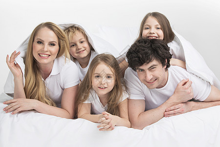 家人在床上微笑父亲孩子乐趣姐姐男生白色兄弟唤醒卧室毯子图片