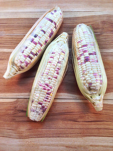 木制背景的白色和紫色玉米图片