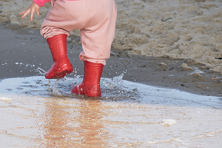 水坑里的井灵 海底的婴儿橡胶靴下雨雨靴乐趣靴子孩子红色橡皮天气照片雨鞋图片
