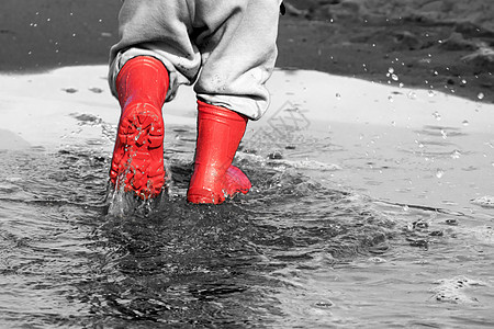 水坑里的井灵 海底的婴儿橡胶靴橡皮雨靴季节乐趣红色下雨靴子孩子飞溅天气图片