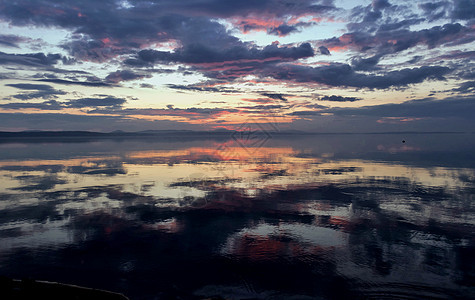 日落时在湖中反射成多彩的天空橙子海浪戏剧性阳光海岸晴天场景环境海滩镜子图片