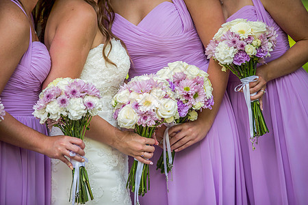 穿紫色礼服的新娘和伴娘 拿着花束图片