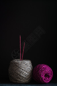 Fuchsia 和灰色的毛纱纹在黑暗木头背景上棉布纺织品风格手工围巾工艺艺术针线活纤维紫红色图片