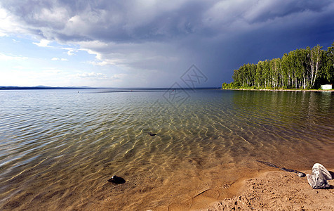 在湖上下雨前的乌云雨森林木头海滩危险天气蓝色波浪闪电日出风暴图片