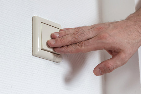 普通房子里的电灯开关按钮手指白色家庭活力力量灰色电气男性塑料图片