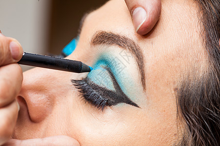 化妆艺术家在白女人的眼神上 应用蓝眼影女士眼睛男人刷子客户铅笔眼影皮肤眉毛化妆品图片