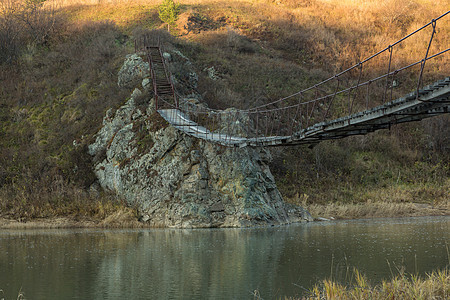 一条小河上那条老旧的吊桥树叶小路游客旅行行人溪流森林木头木板冒险图片