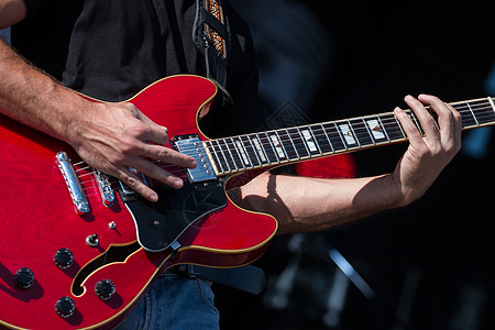吉他玩家在音乐会上演奏艺术家字符串音乐音乐家乐队红色展示蓝调摇滚乐岩石图片