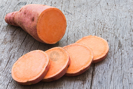 甜土豆和木本底切片 生菜红色马铃薯团体橙子块茎蔬菜木头番薯烹饪农业图片