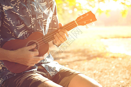 音乐乐器和表演者手在公园里玩的吉他演奏会派对流行音乐笔记岩石旋律脖子手指排练木头音乐家图片