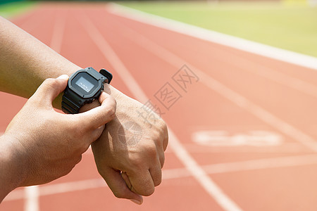 Athlete检查他的手表 比赛计时员跑步者准备在赛道上运行图片
