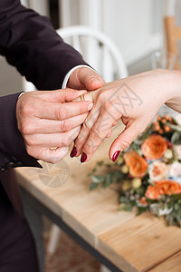 结婚戒指和新娘和新郎的手 新婚夫妇在仪式上 婚姻 恋爱中的男人和女人 两个快乐的人庆祝成为一家人手指夫妻裙子胸花花束金子交换玫瑰图片