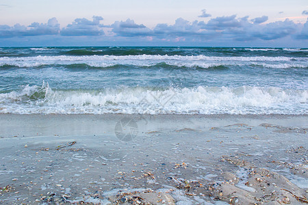 海滨海浪在空沙滩上滚动 暴风日出图片