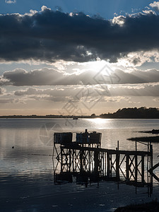 在河湖的木制结构码头上 在船码头对面日落图片