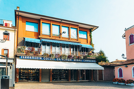 意大利古老省镇Caorle旅游区 意大利街道蓝色城市自行车旅游路面房屋黄色餐厅长凳图片
