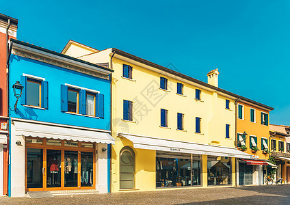 意大利古老省镇Caorle旅游区 意大利黄色城市路面餐厅房屋街道蓝色旅游长凳海岸图片