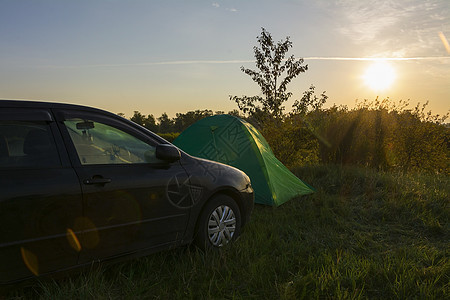 在阳光明媚的清晨夏日风景背景露营帐篷和汽车中扎营图片