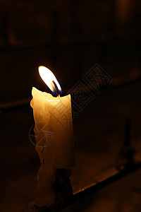 黑暗教堂的白蜡烛烧着图片