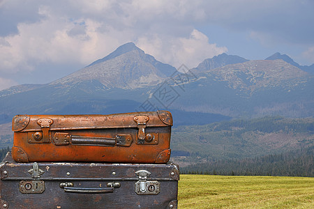 跨越山地的古老旅行行李箱图片