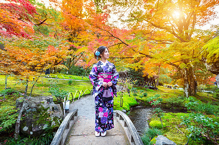 秋天公园的亚洲妇女穿着日本传统和服裙子绿色寺庙衣服文化花园女孩红色橙子旅行图片