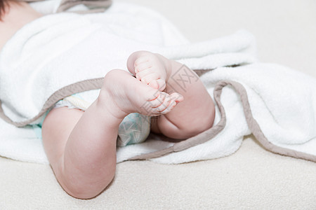 围着可爱新生儿脚的白毛巾 近距离看一幅新出生婴儿脚印在白纸上的照片图片